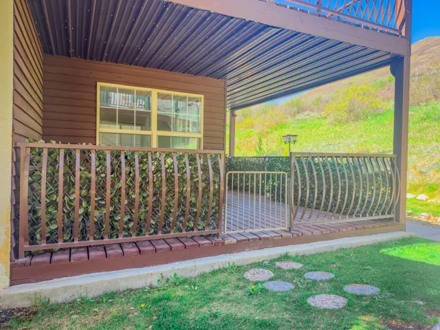 Covered patio featuring a corrugated metal ceiling and wood-finish decking