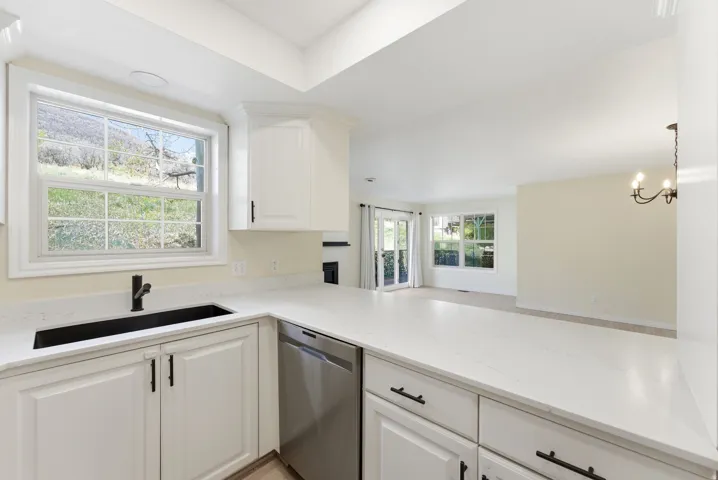 Swiss Oaks condo kitchen with counter seating, modern cabinetry, and direct sightlines to living and dining areas