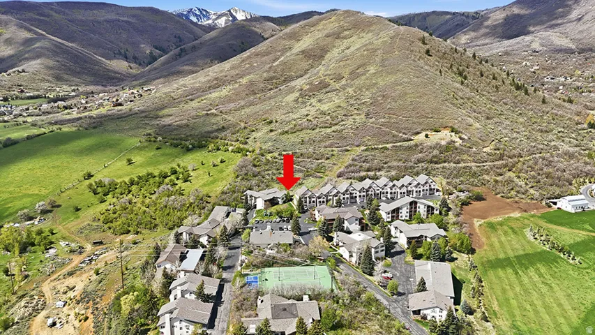 Midway condo for sale aerial with trail system, green space, and mountain views in background. Highlights the connection between the community and nearby trails.
