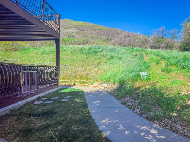 Ground-level patio with decorative metal railing and concrete walkway