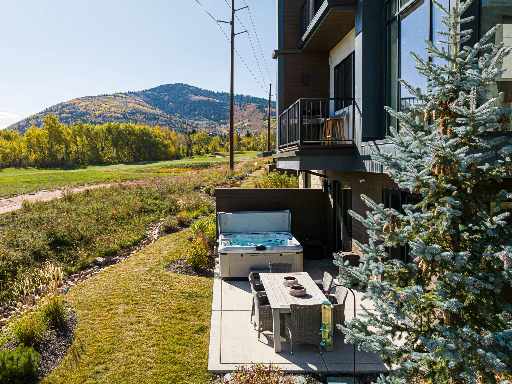Patio / terrace with a mountain view, a hot tub, a lawn, and a patio area