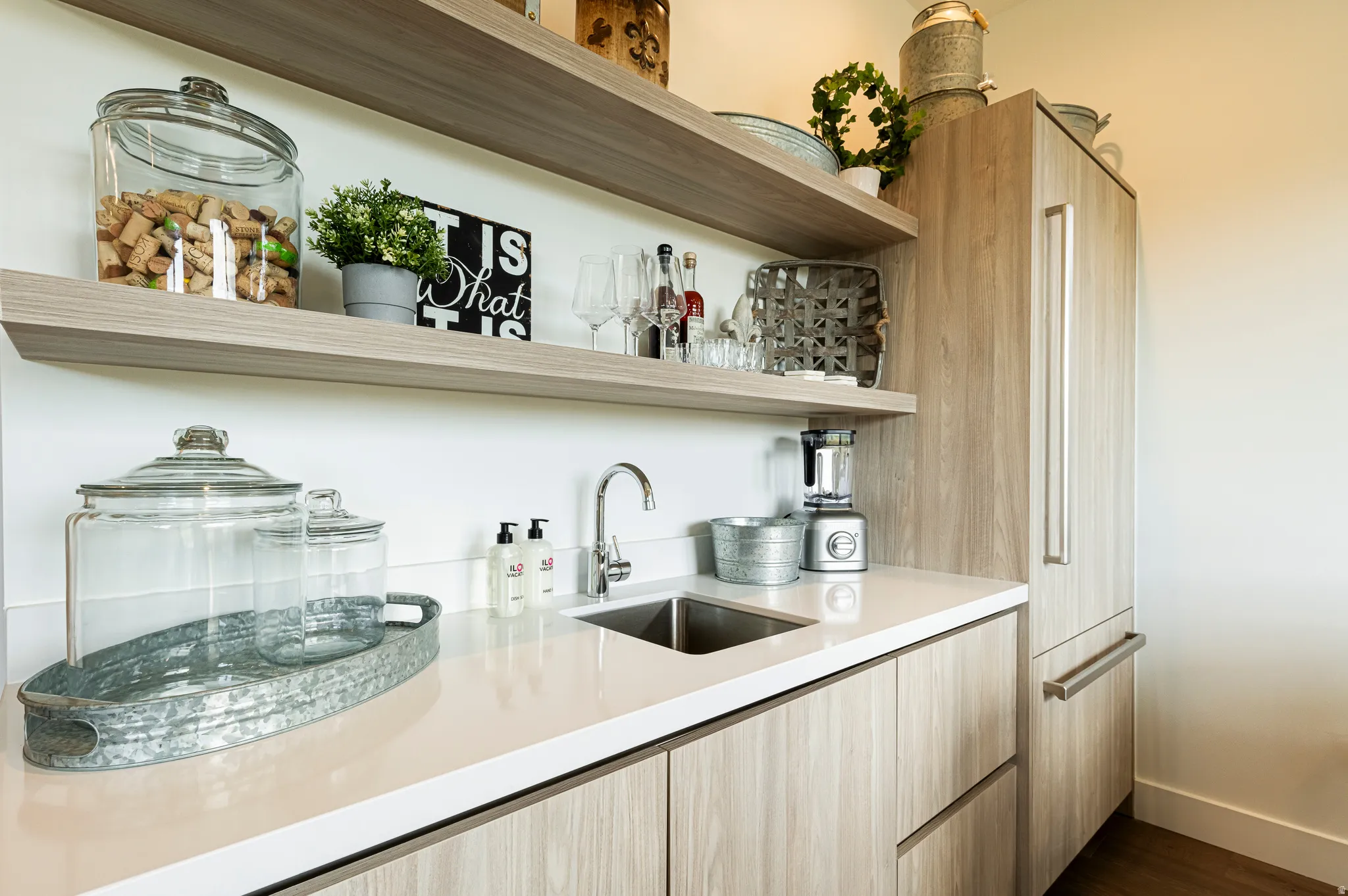 Bar area featuring open shelves, light wood finish cabinets, modern cabinets, dark wood-style flooring, and light stone counters