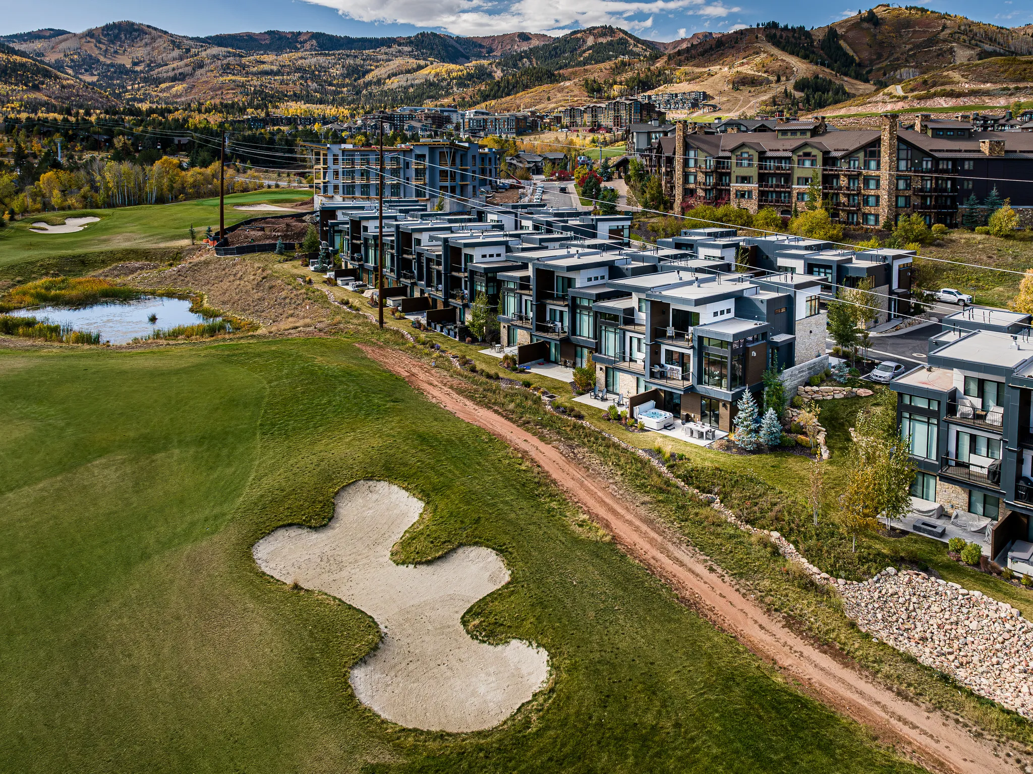 Drone / aerial view of a golf course and a water and mountain view