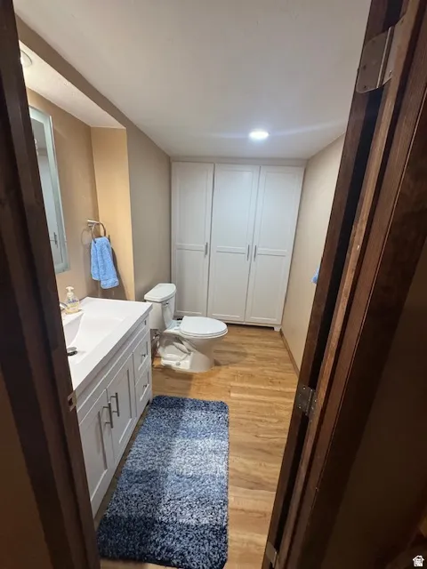 Half bath featuring vanity, light wood-style floors, and recessed lighting