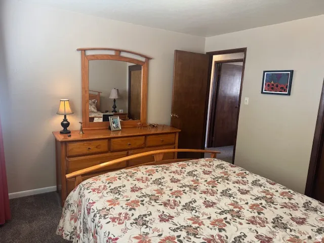 Bedroom featuring dark carpet