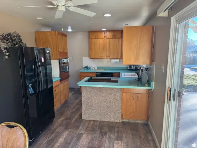 Kitchen featuring black appliances, a peninsula, wood finish cabinets, and recessed lighting
