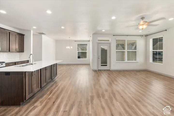 Open-concept living area featuring wood-finish flooring, recessed lighting, and a ceiling fan