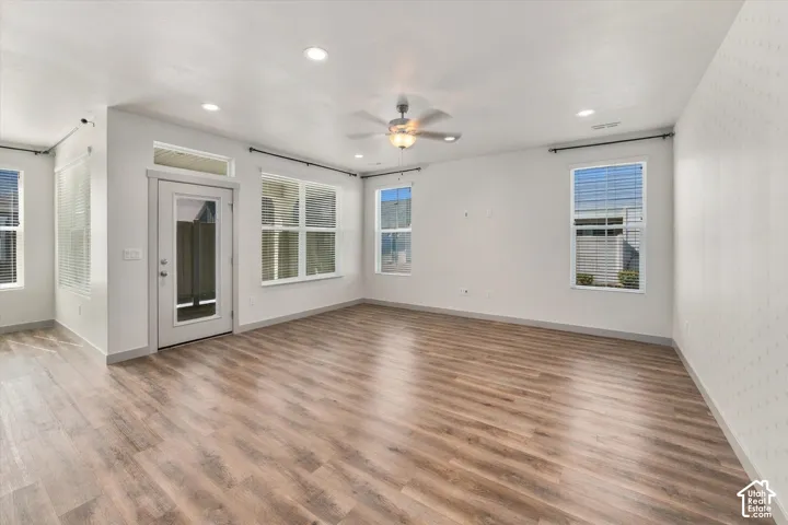 Wood-finish flooring throughout, recessed lighting, and multiple windows with blinds