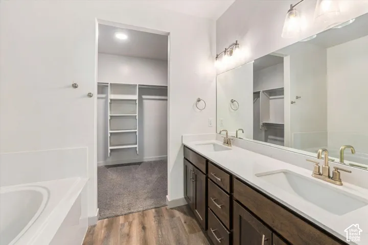 Dual vanity with white countertops, undermount sinks, and brass-finish fixtures