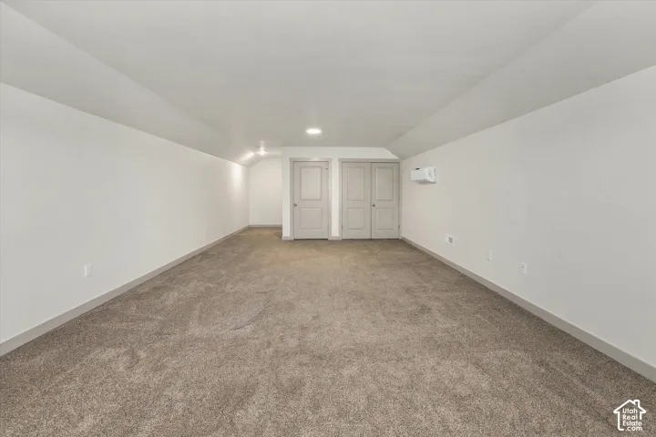 Spacious room with plush carpeting, neutral wall finishes, recessed lighting, and two panel doors