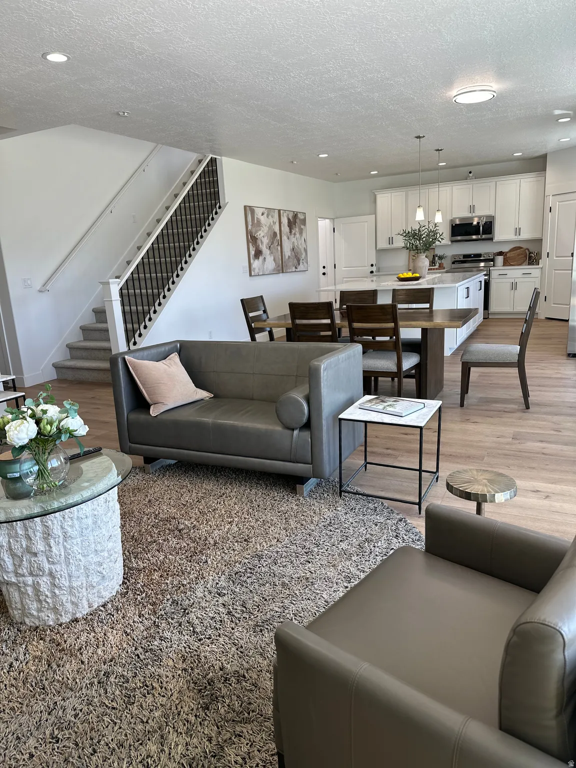 Living area with light wood-style floors, recessed lighting, and a textured ceiling