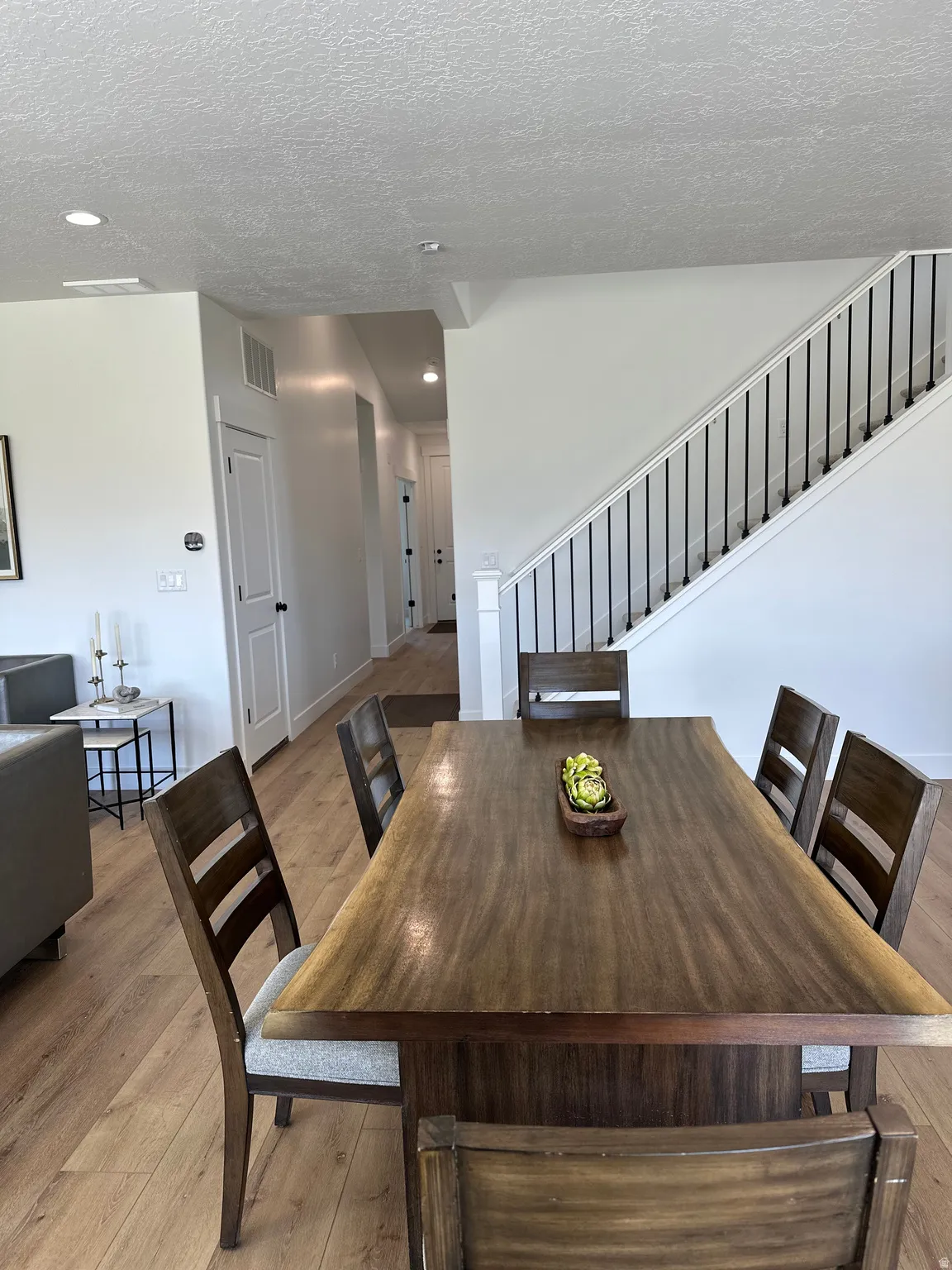 Dining room featuring light wood-style flooring, a textured ceiling, and recessed lighting