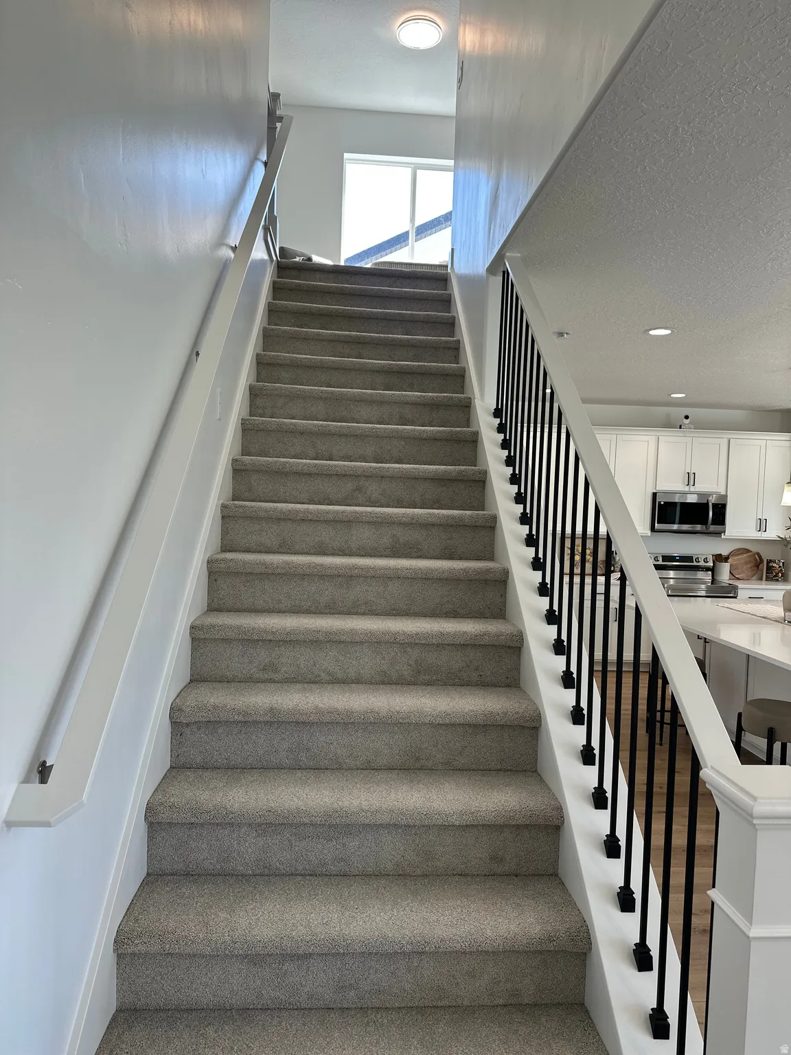 Staircase featuring a textured ceiling and recessed lighting