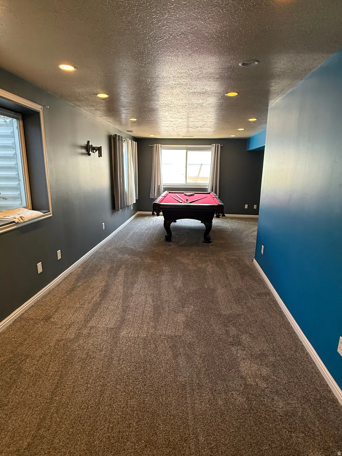 Spacious recreational room featuring recessed lighting, a window with white trim, and light brown carpeting