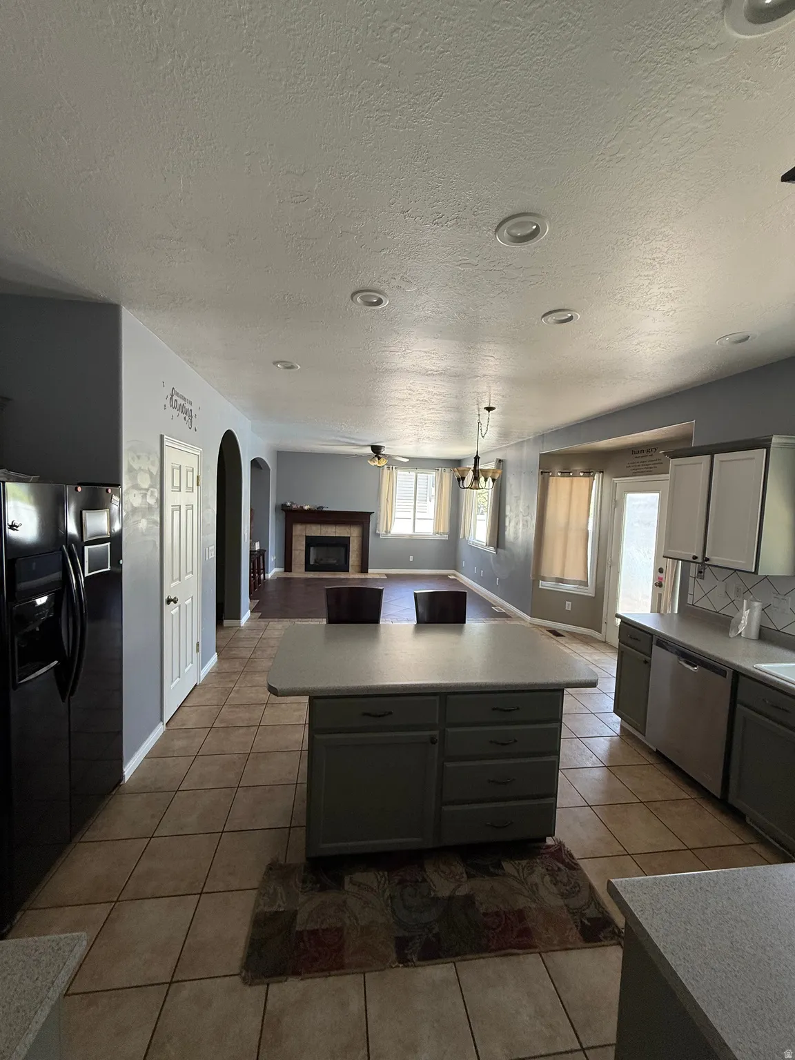 Open-concept kitchen featuring tile flooring and an island with counter seating