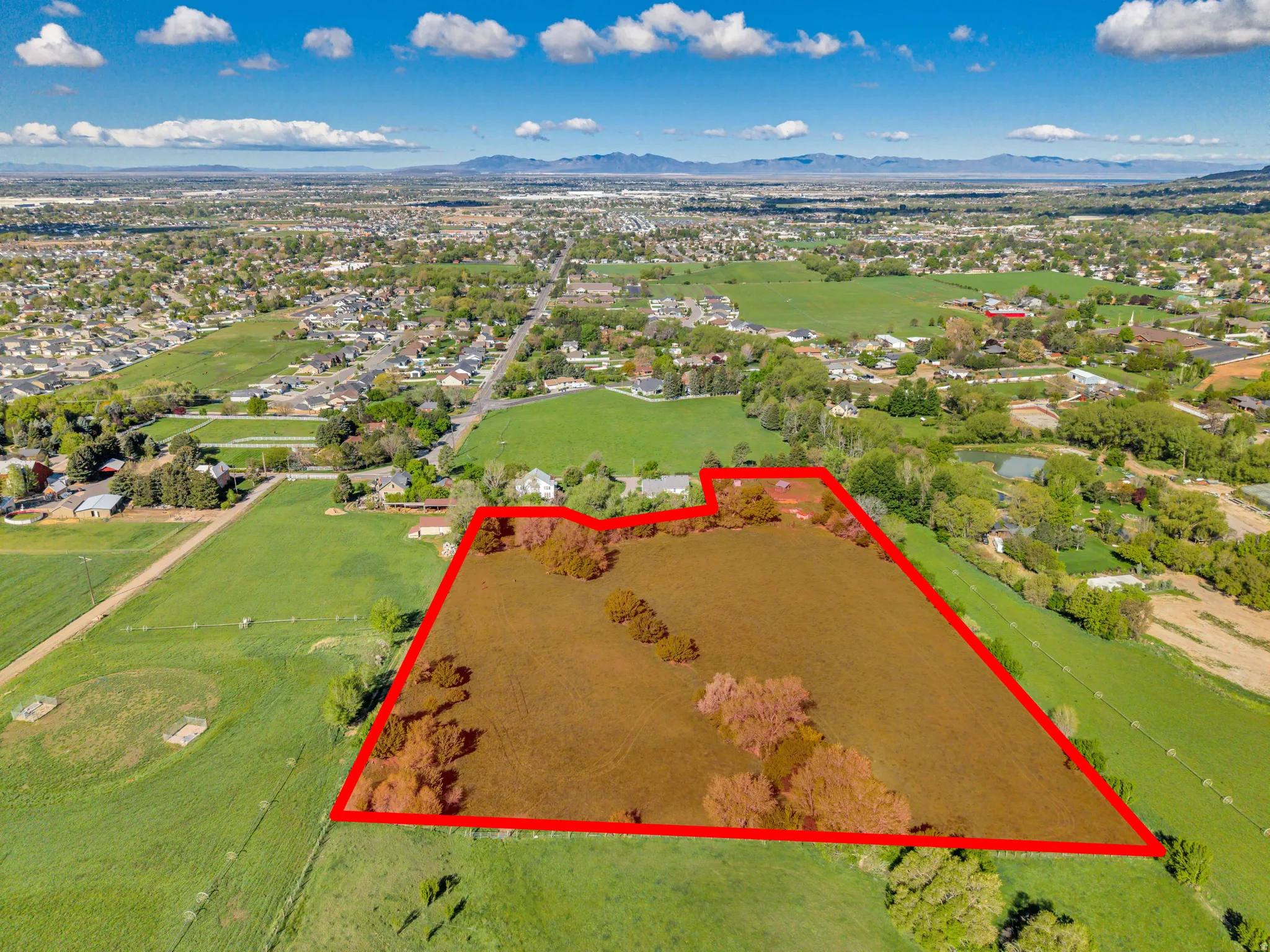 Aerial view of property and surrounding area featuring property parcel outlined and a mountain backdrop