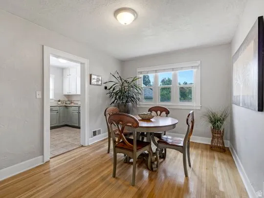Dining space with light wood-type flooring and a textured ceiling