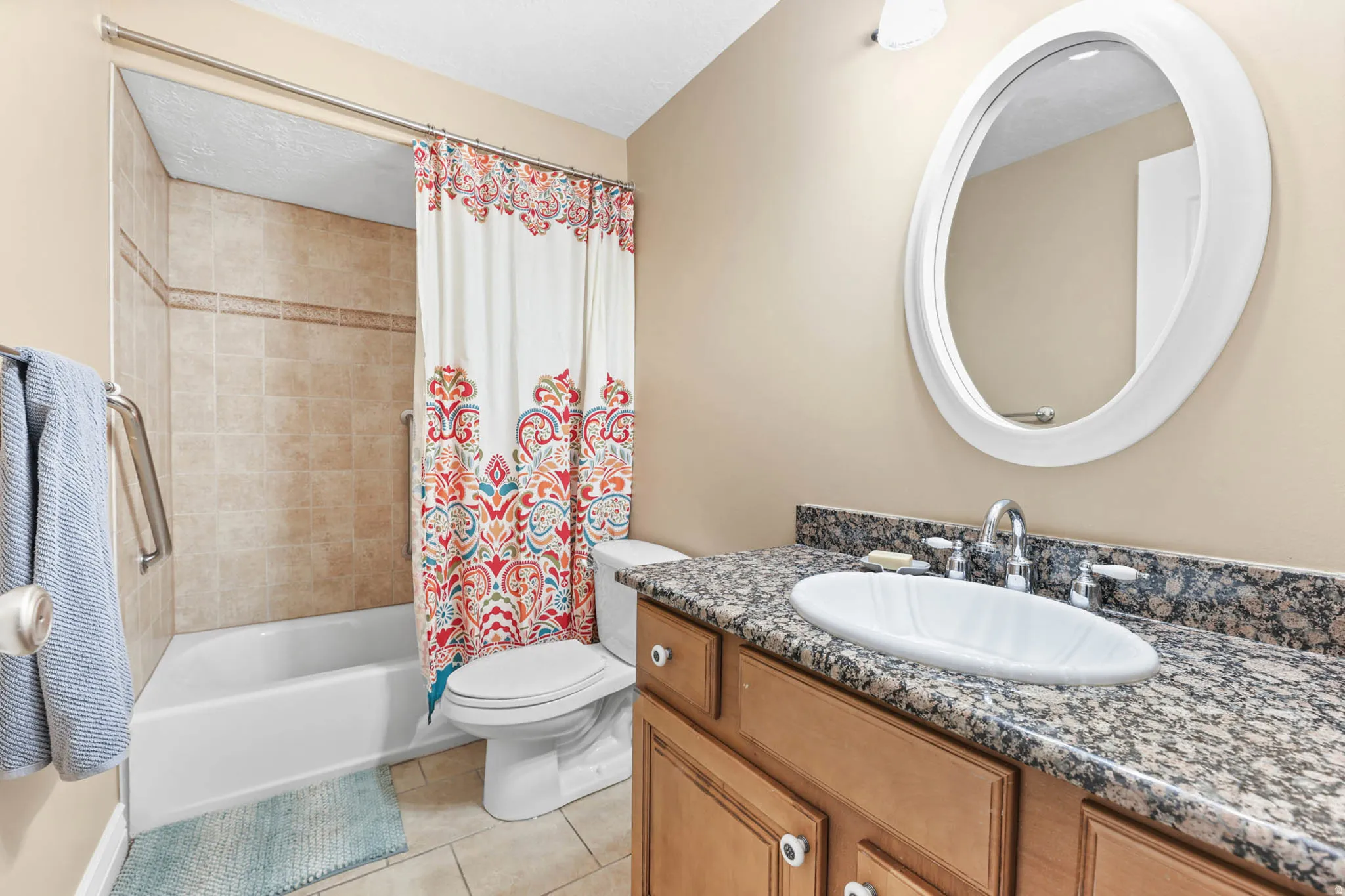 Full bathroom with vanity, light tile patterned floors, and shower / tub combo with curtain