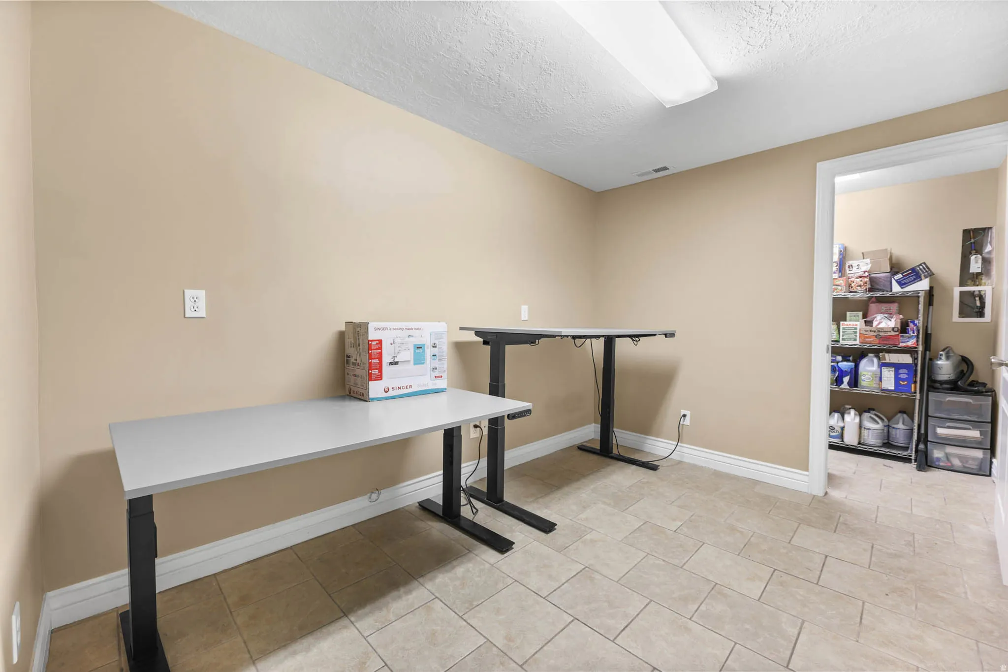 Office with a textured ceiling and light tile patterned floors