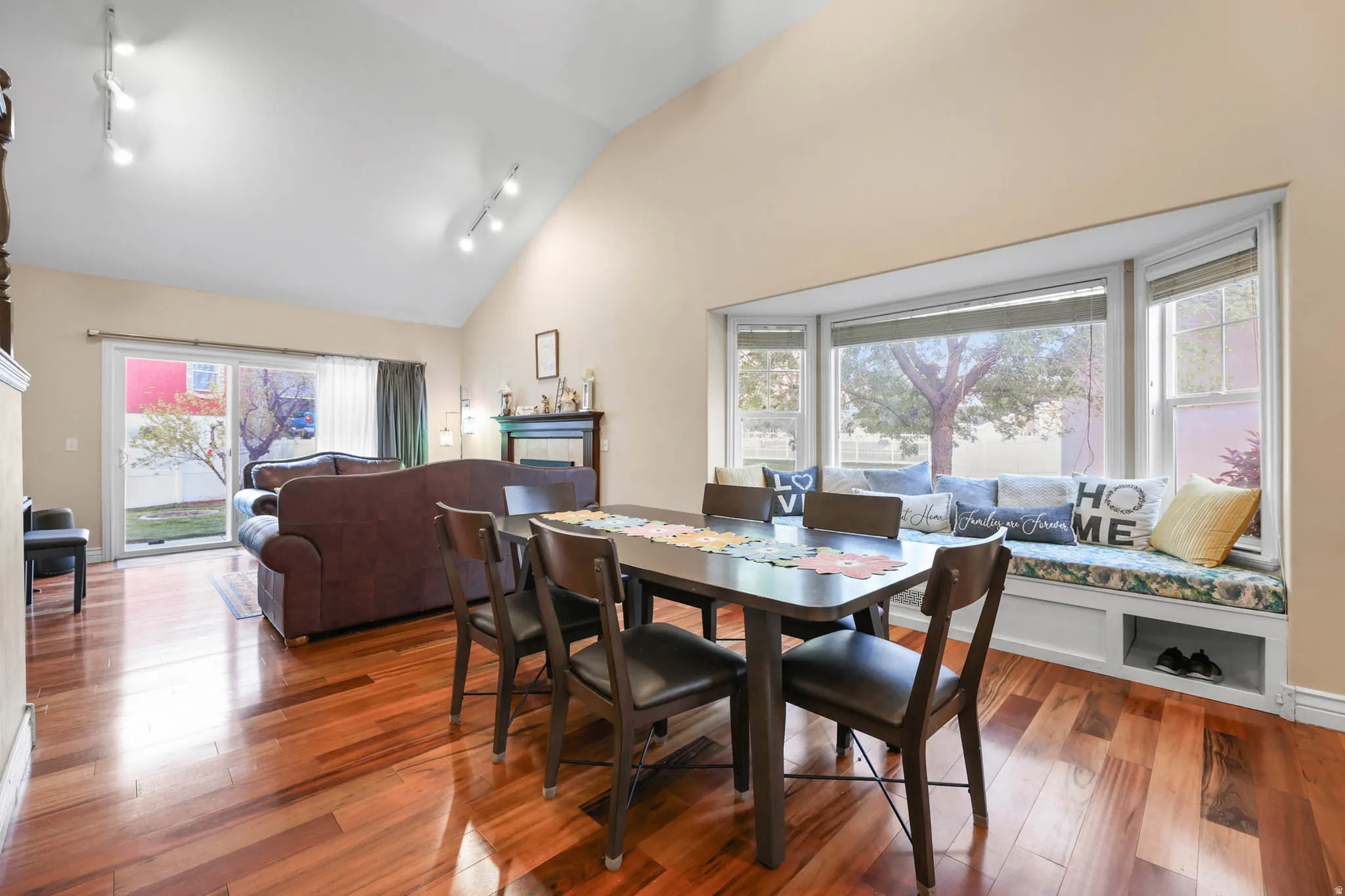 Dining area featuring track lighting, hardwood / wood-style floors, and vaulted ceiling