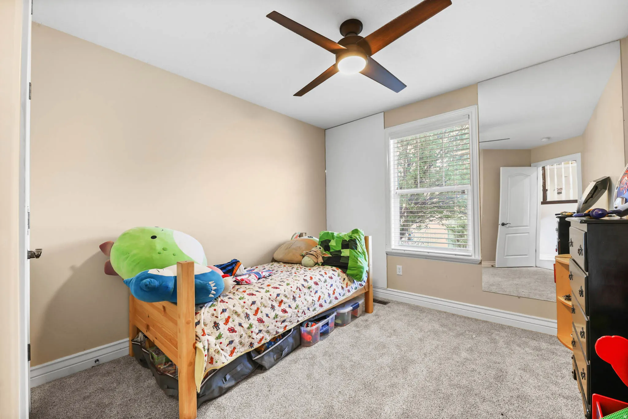 Carpeted bedroom featuring baseboards and ceiling fan