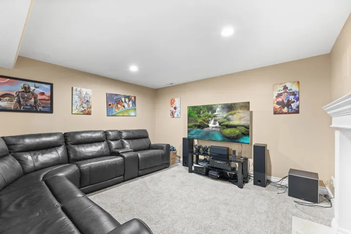 Carpeted living area with recessed lighting and baseboards