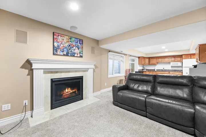 Living area with light colored carpet, recessed lighting, and a fireplace