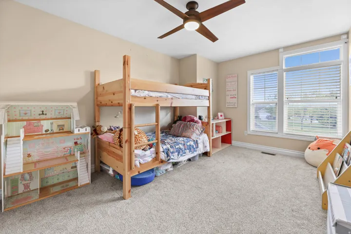 Bedroom featuring light carpet and ceiling fan