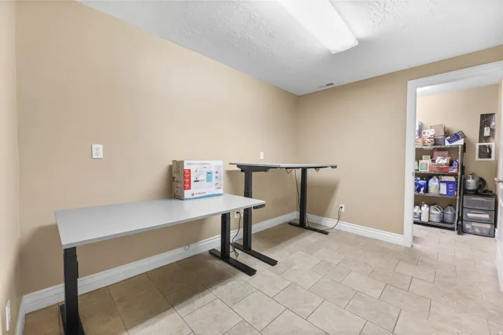 Office with a textured ceiling and light tile patterned floors