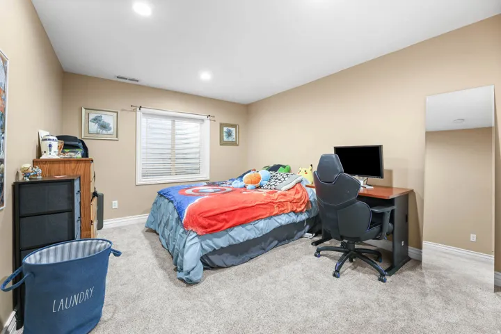 Bedroom with light carpet and a desk