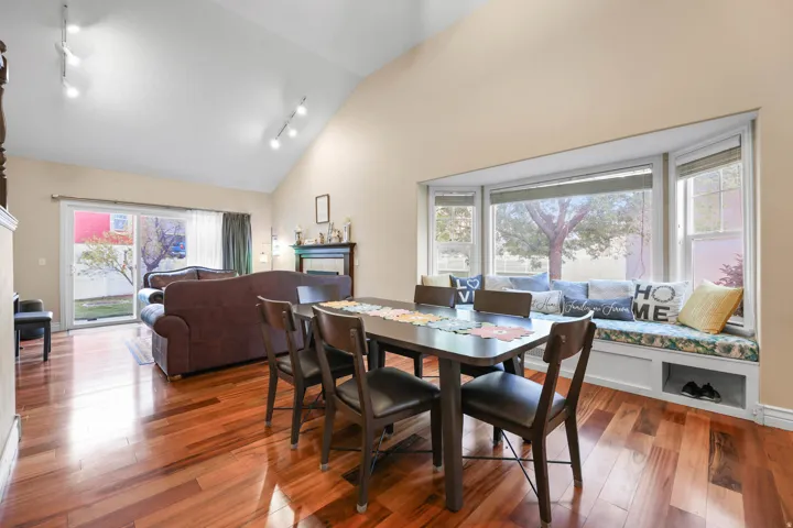 Dining area featuring track lighting, hardwood / wood-style floors, and vaulted ceiling