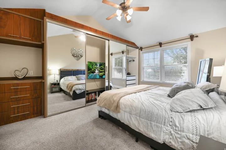 Bedroom featuring light colored carpet, a closet, and ceiling fan