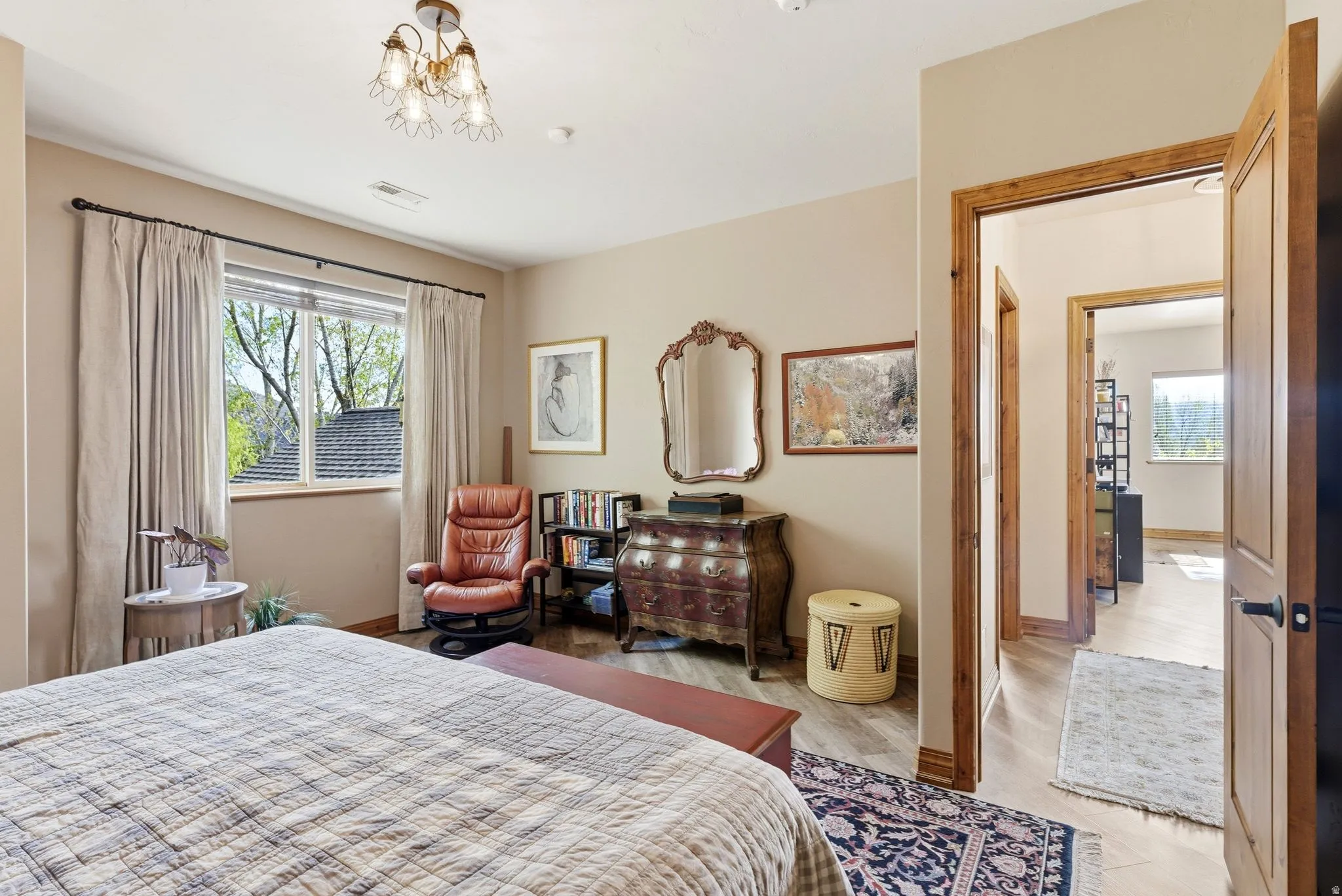 Bedroom with hanging lights and light wood-type flooring