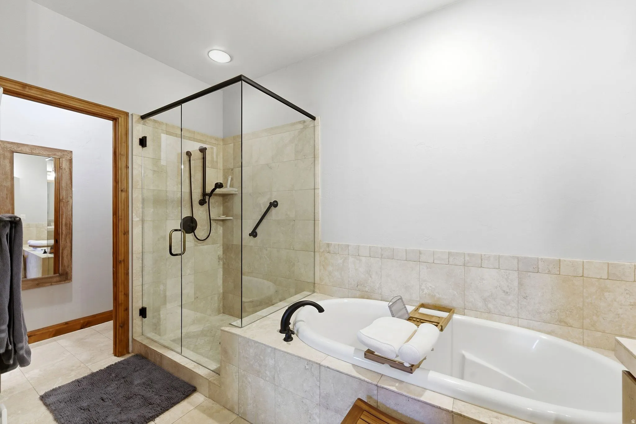 Bathroom featuring a shower stall, a bath, and light tile patterned flooring