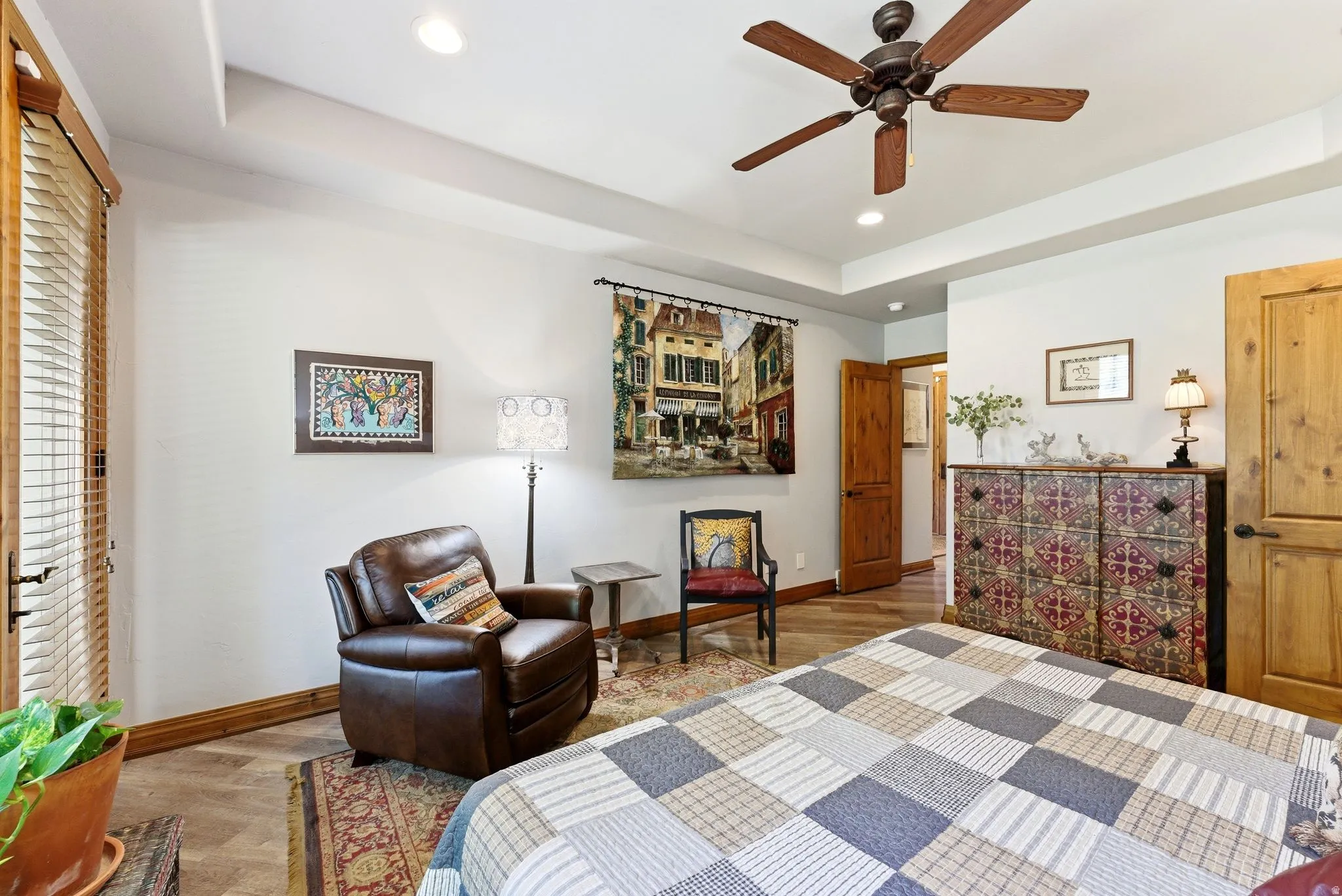 Bedroom featuring a raised ceiling, light wood finished floors, a ceiling fan, and recessed lighting