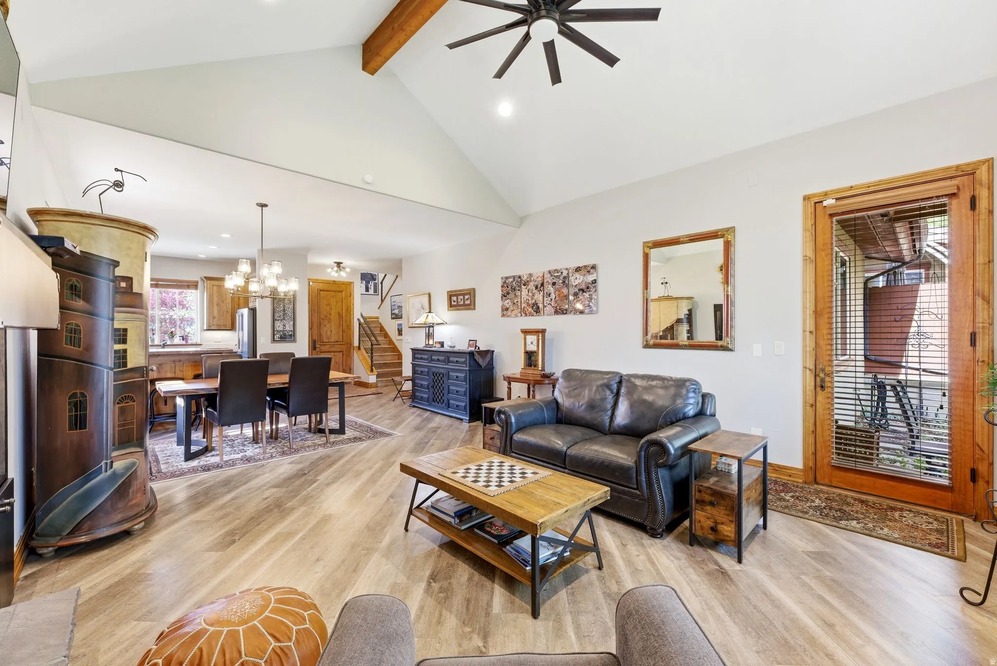 Living room with light wood finished floors, suspended lighting, and ceiling fan
