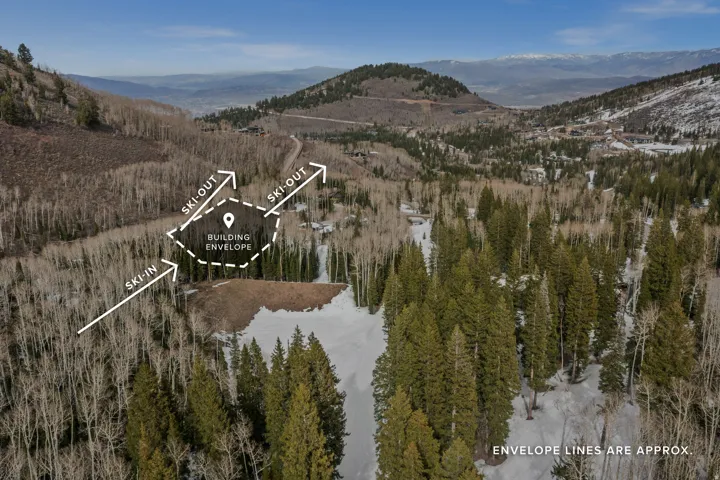 Aerial view of property and surrounding area featuring a mountain backdrop and property boundaries highlighted