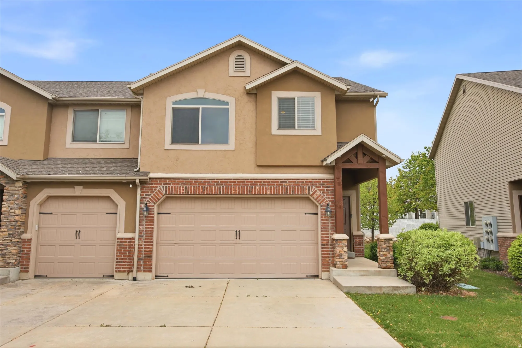 Traditional-style home featuring a garage, stucco siding, concrete driveway, and roof with shingles