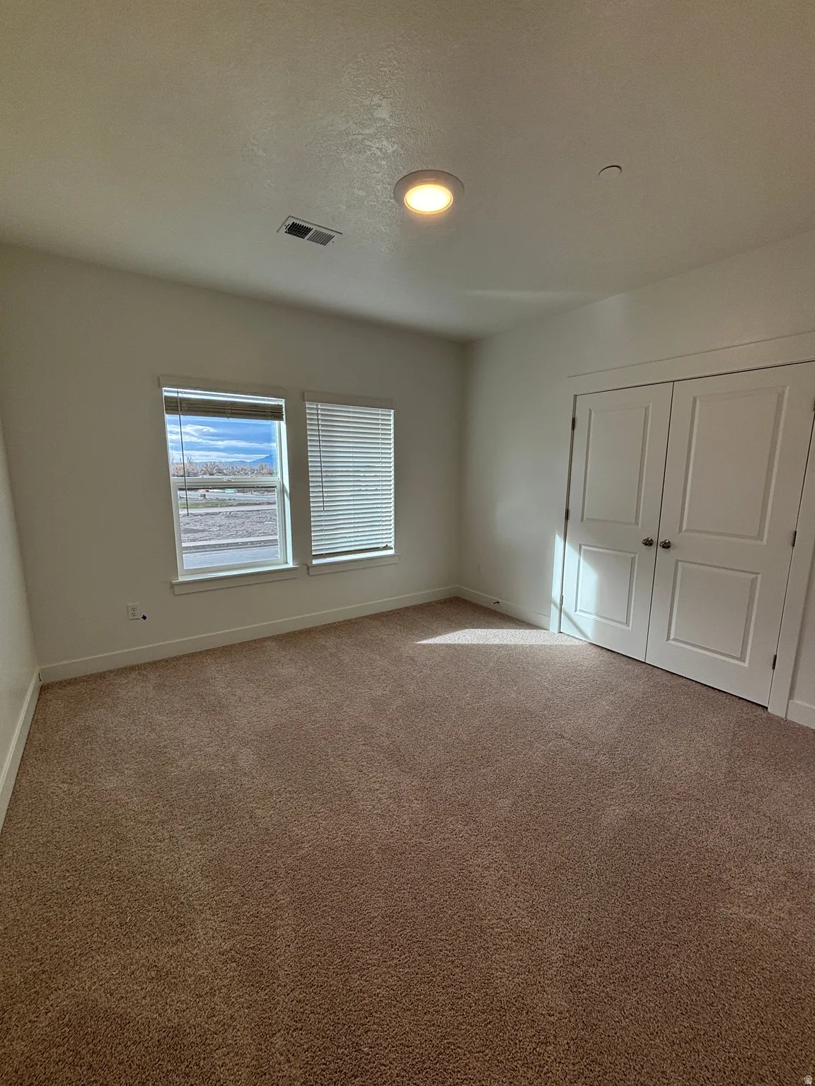 Unfurnished bedroom featuring carpet, a closet, and a textured ceiling