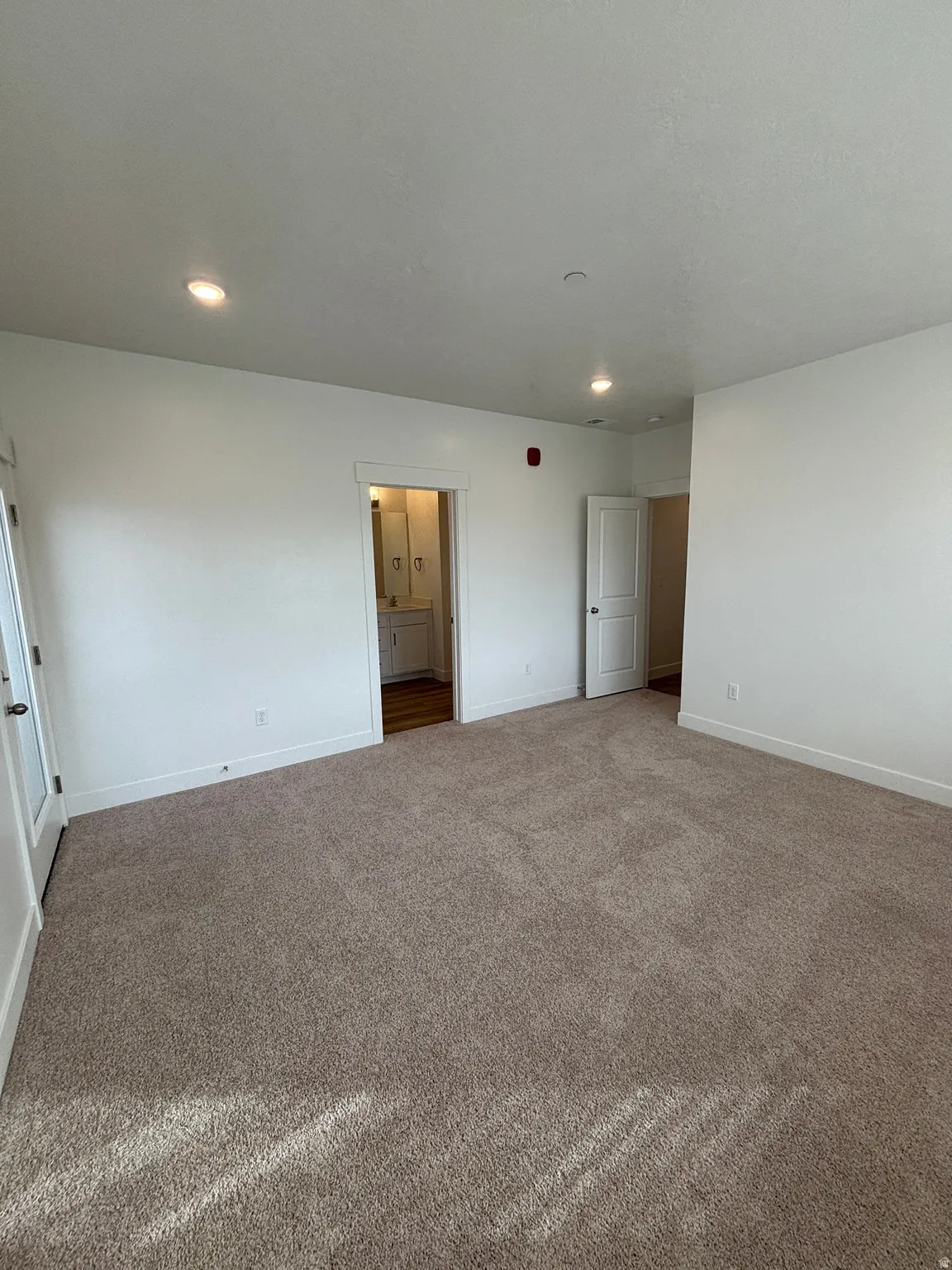 Unfurnished bedroom featuring carpet floors, recessed lighting, and ensuite bathroom