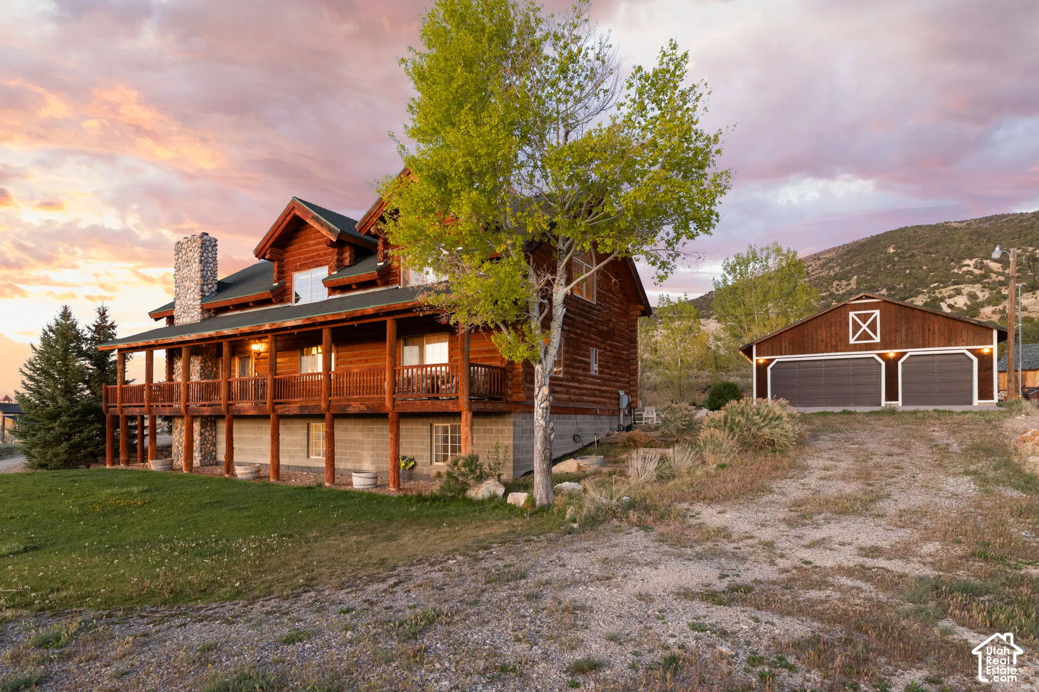 View of front facade featuring a garage, sauna, a stunning wraparound porch, a front lawn, and rocked chimney