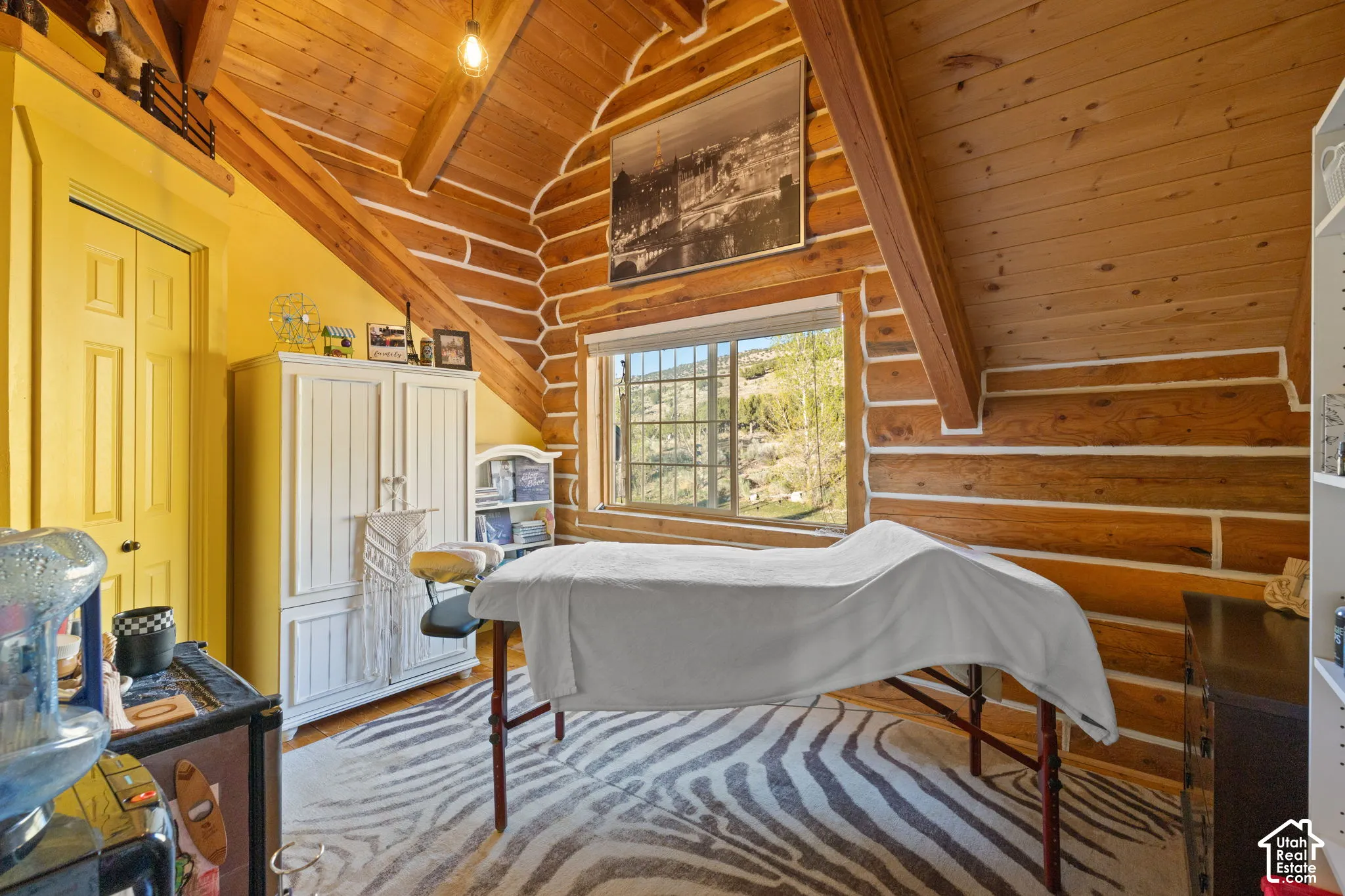 Bedroom featuring log walls, wooden ceiling, light wood-type flooring, lofted ceiling with beams, and a closet with an upper loft area