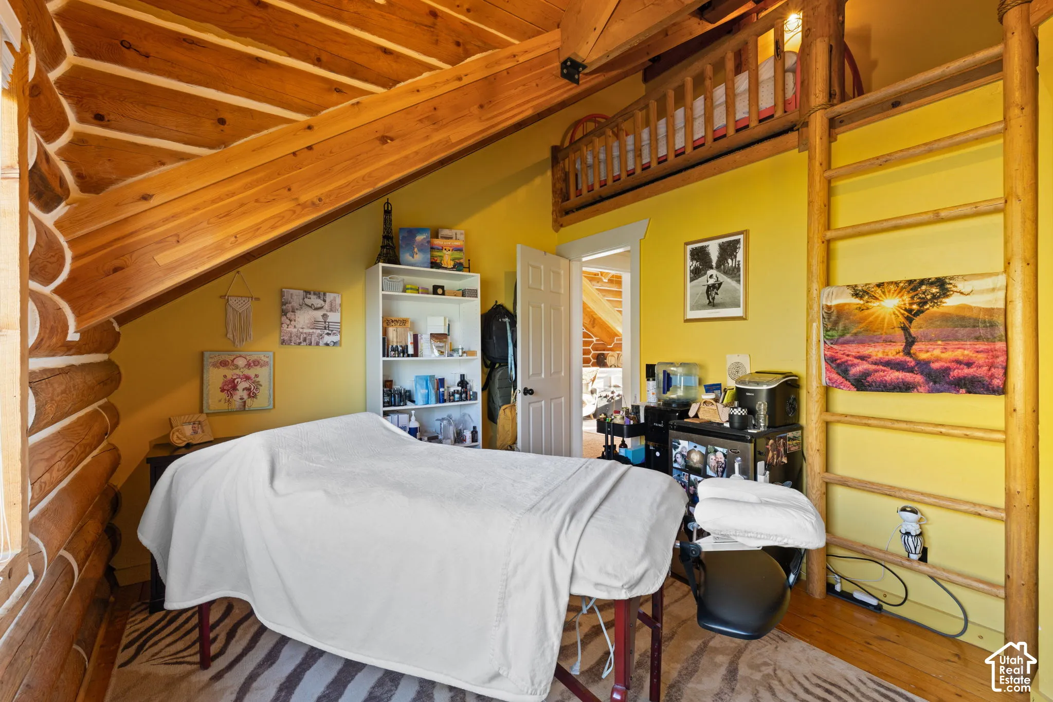 Bedroom featuring log walls, wooden ceiling, light wood-type flooring, lofted ceiling with beams, and a closet with an upper loft area