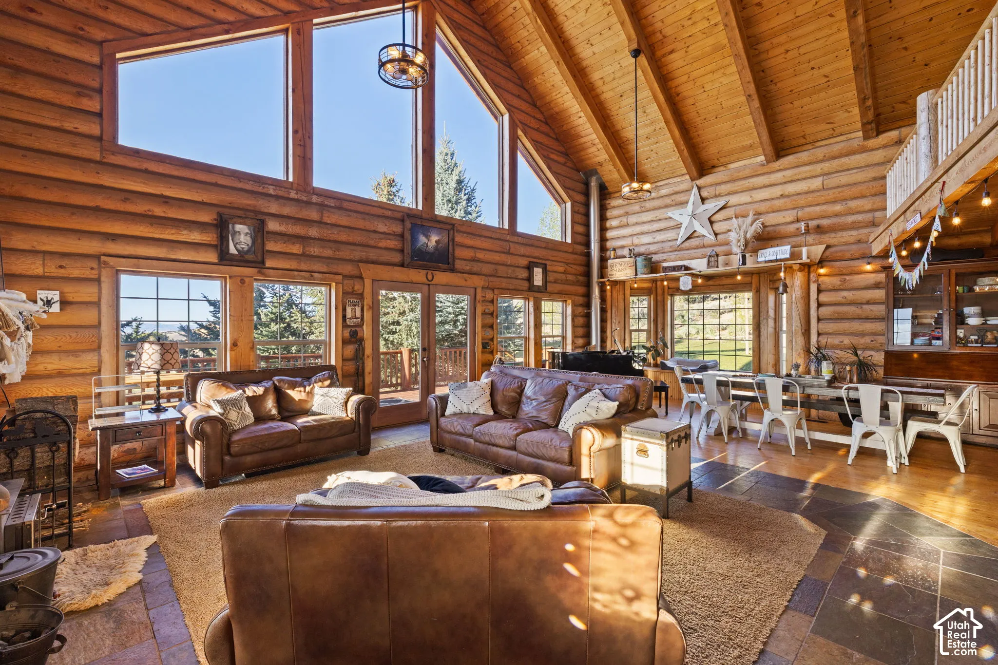 Living area featuring log walls, french doors, a high wood beamed ceiling, and stone tile floors and ample natural lighting