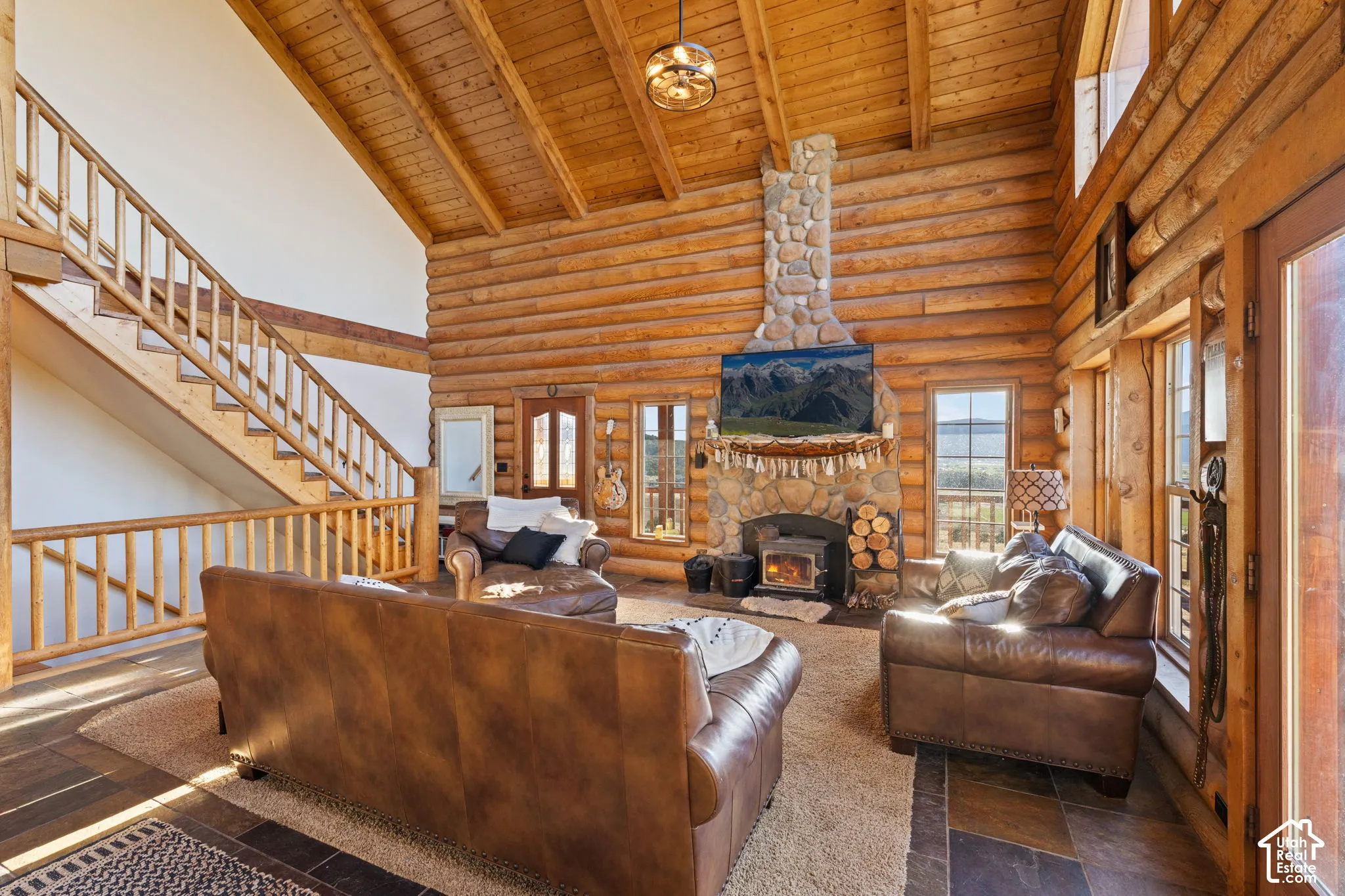 Living room with a fireplace and rustic walls, ample natural lighting