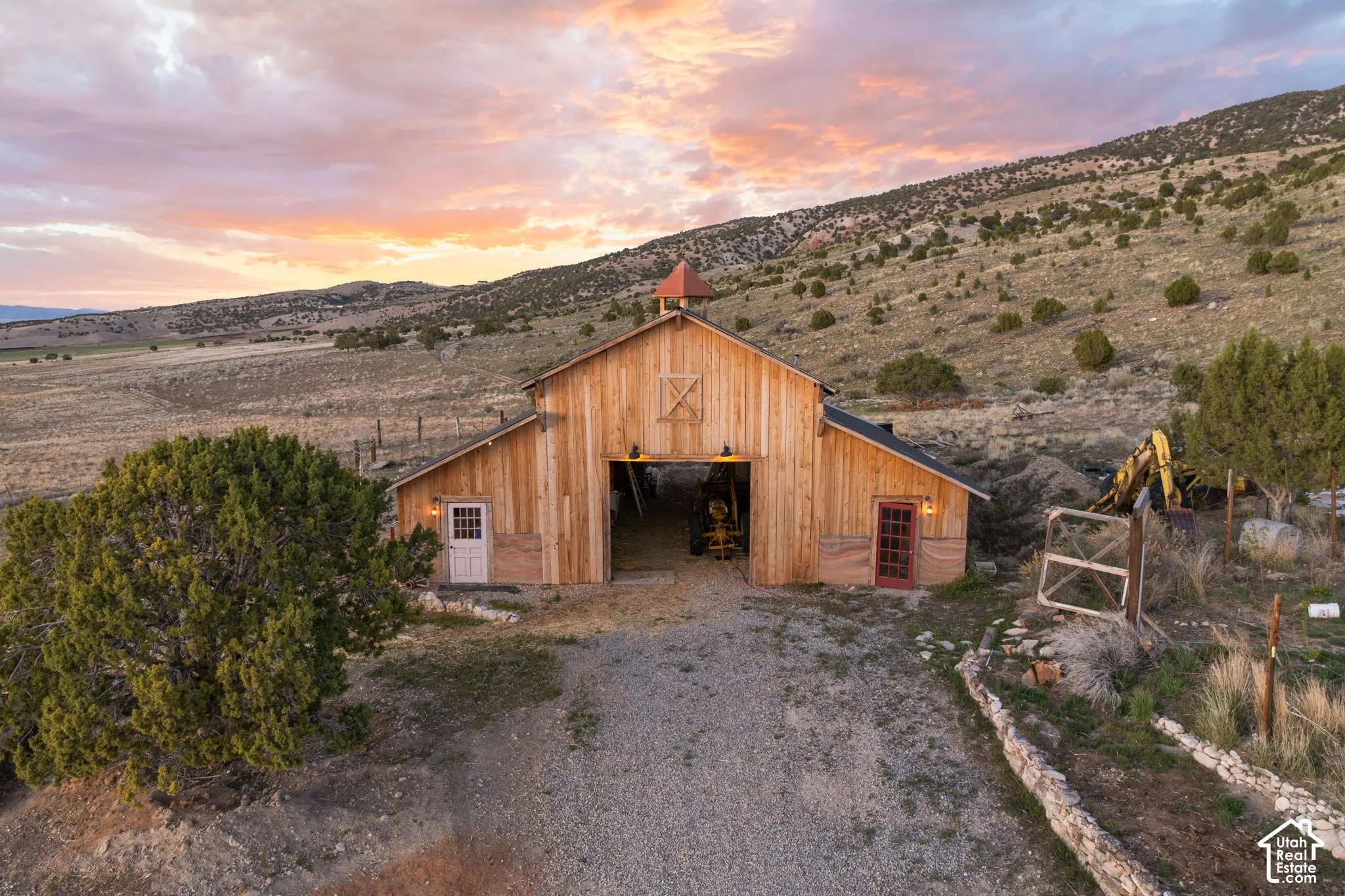 Outdoor structure at dusk with a barn, a mountain view, and driveway