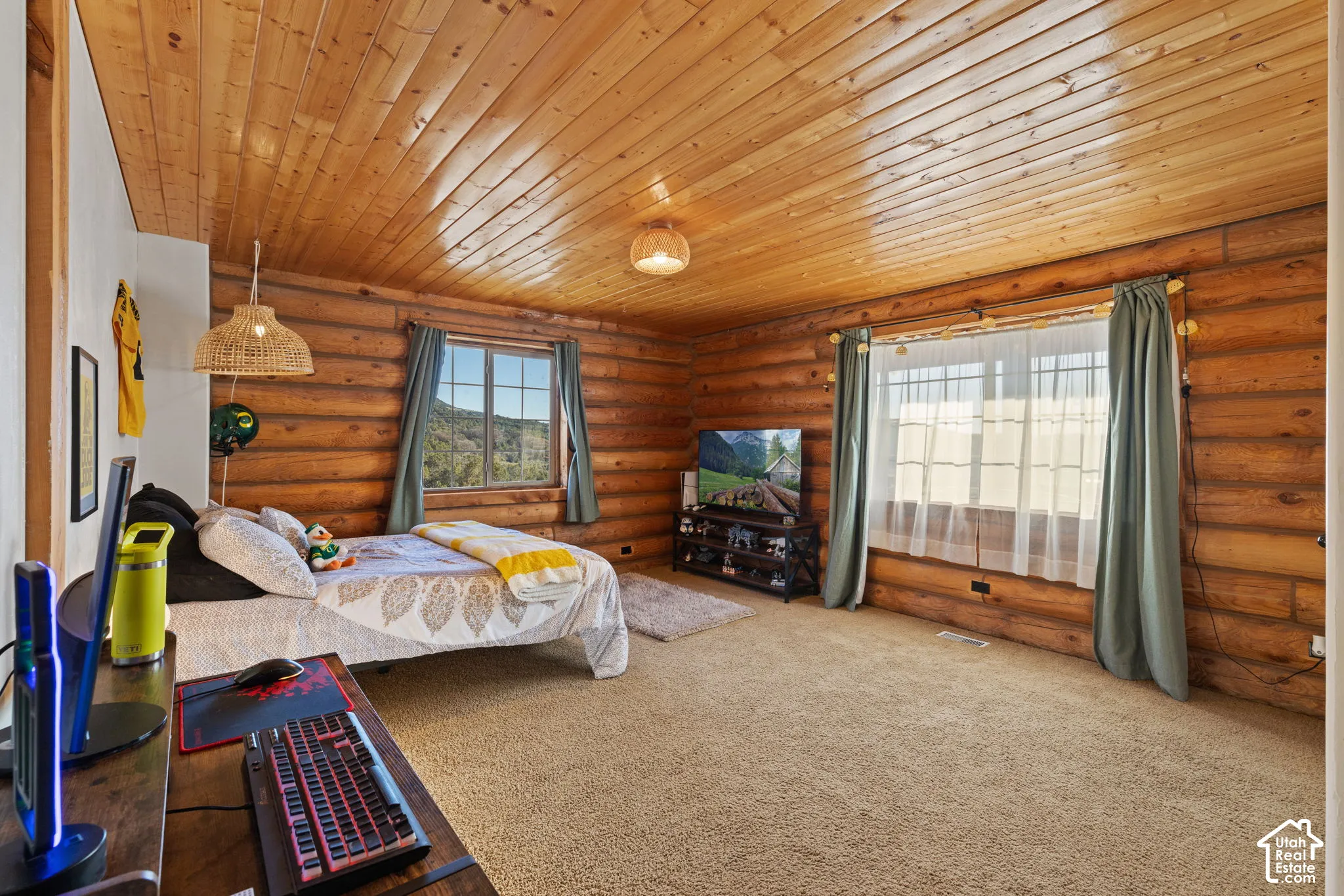 Carpeted bedroom featuring wooden ceiling and rustic walls