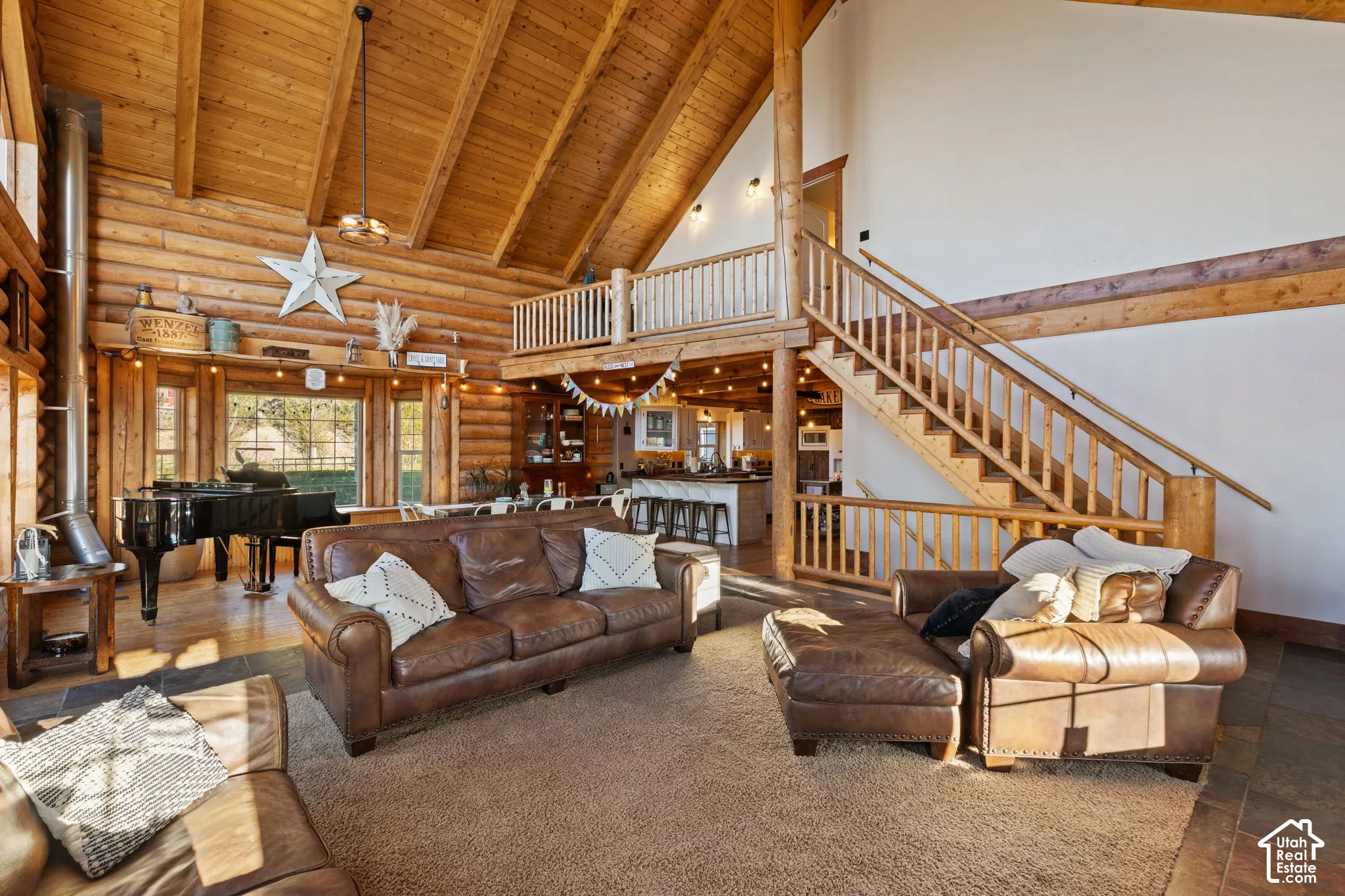 Carpeted living area with a high wooden beamed ceiling and rustic walls