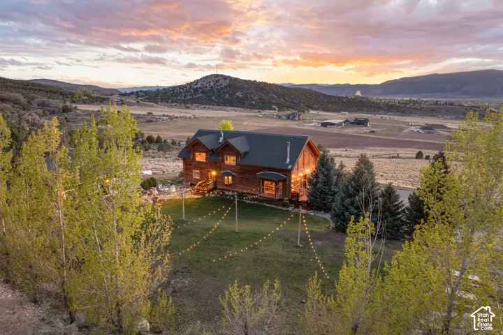 Back of property with a mountain view and a lawn