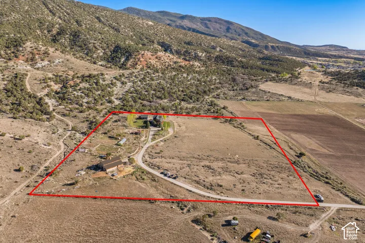 Aerial view of sparsely populated area featuring property boundaries highlighted and mountains